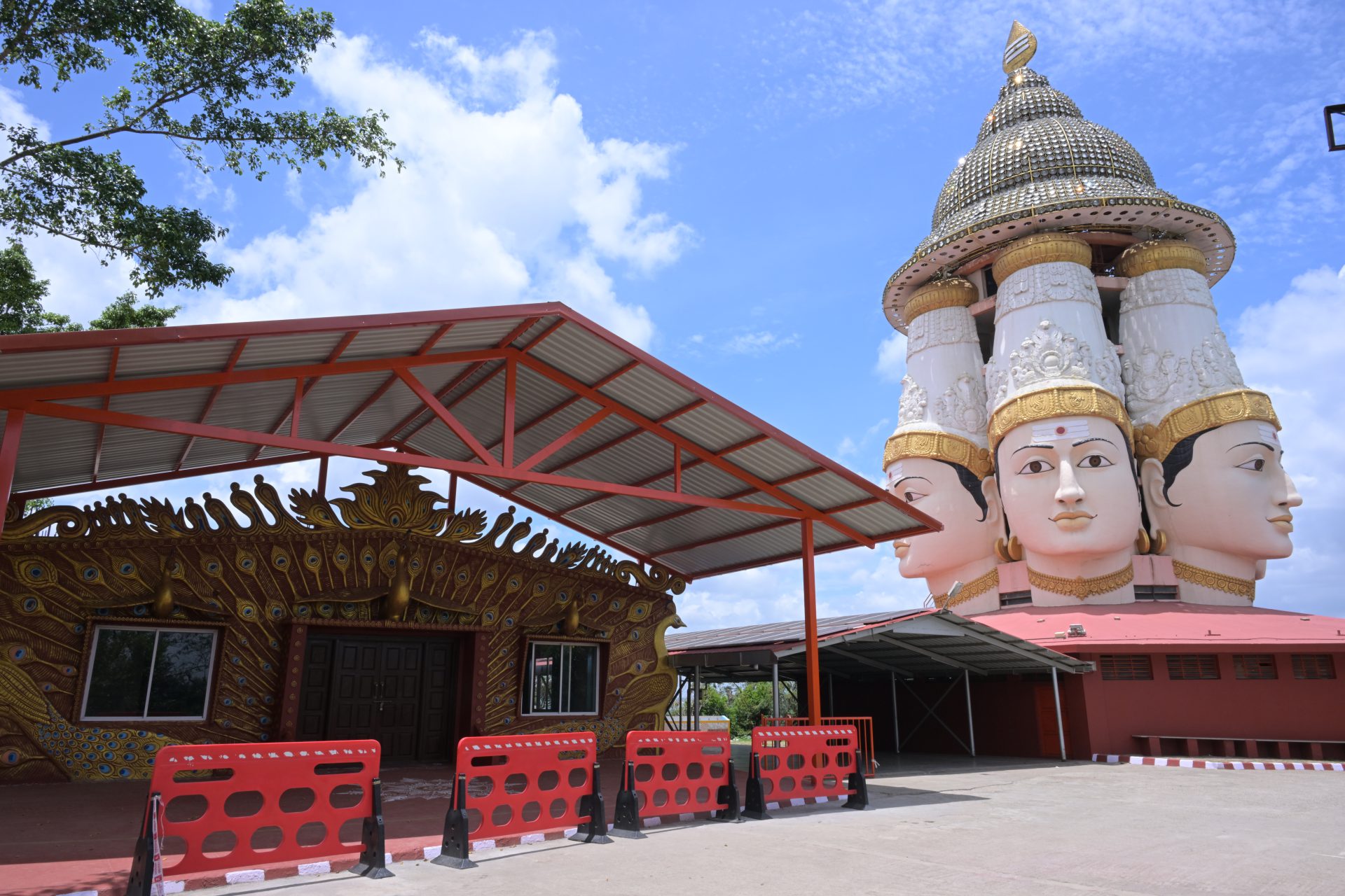 Shanmuga Hall — peacock-motif facade beside the temple's multi-headed deity shrine